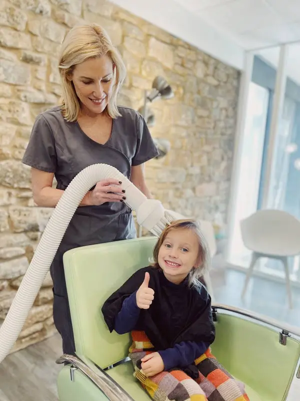 Child receiving heated air lice treatment at Lice Clinics of Texas